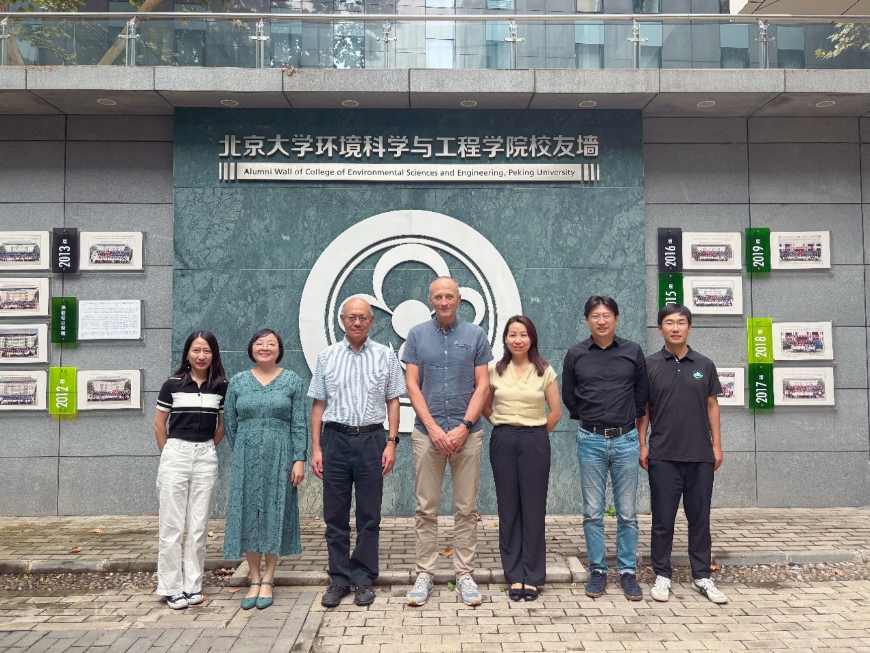 A group of people standing in front of a building

Description automatically generated